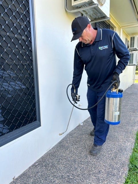 A pest control treatment being completed outside a house in Mount Sheridan